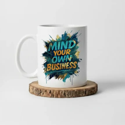 11oz White ceramic coffee mug with “Mind Your Own Business” text placed on a wooden stand.
