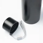 Top-down view of an HL NOVA matte black water bottle with the cap removed, highlighting the black threaded lid and a durable grey carrying strap on a white background.