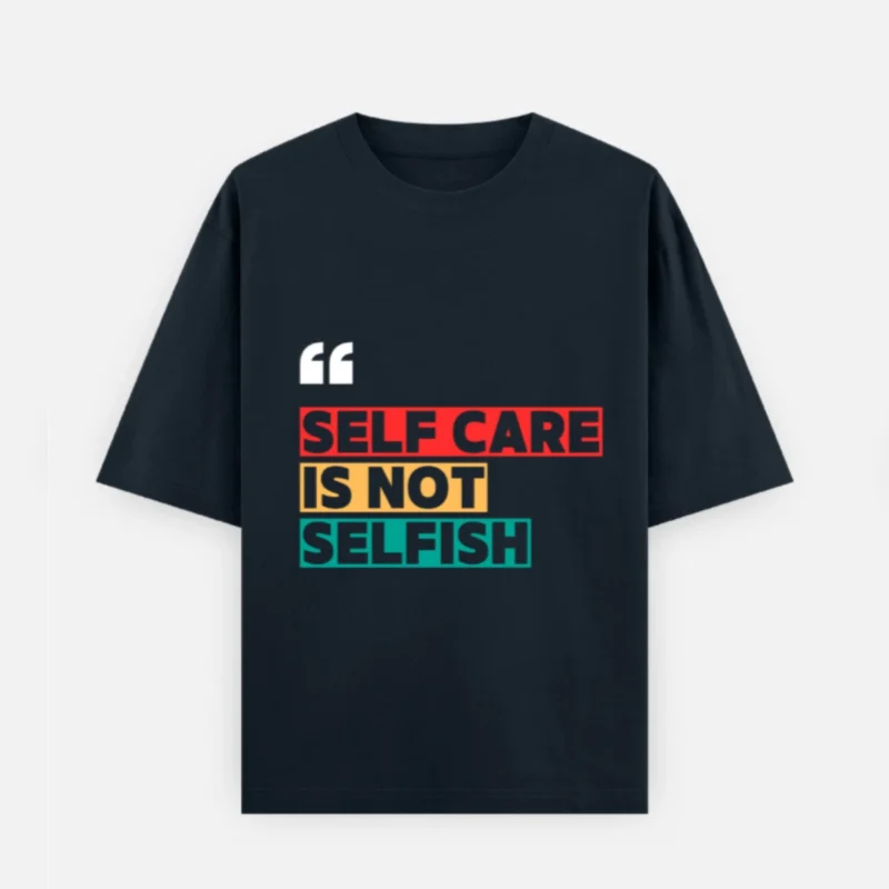 Front view of a deep navy blue unisex oversized t-shirt made of 240 GSM heavyweight cotton. It features white quotation marks and the text "SELF CARE IS NOT SELFISH" highlighted in contrasting red, yellow, and teal block graphics across the chest, designed with dropped shoulders for a relaxed fit.
