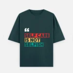 Front view of a petrol blue unisex oversized heavyweight t-shirt. The front features a vibrant graphic text design stating "SELF CARE IS NOT SELFISH" under white quote marks, styled in red, yellow, and teal blocks that pop against the unique teal-blue hue of the 100% cotton fabric.